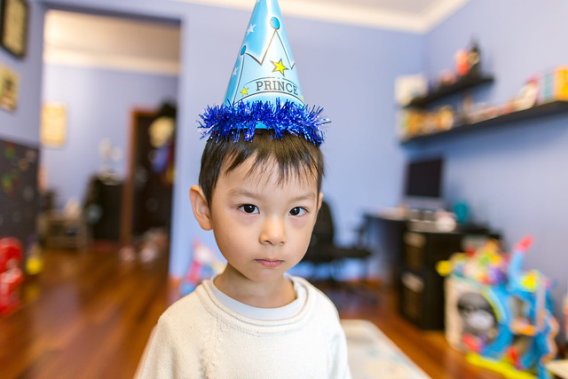 Portrait of a baby boy wearing a party hat and looking at camera at home