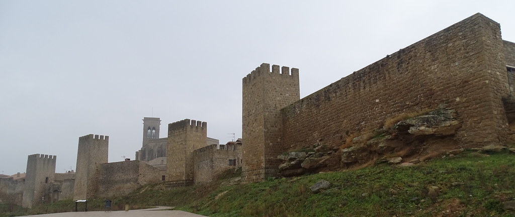 Iglesia fortaleza de San Saturnino puerta arco de San Miguel exterior de torre de muralla y casas del Cerco de Artajona Navarra 