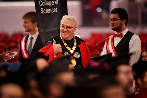 Chancellor Randy Woodson gives the thumbs up to some students as he enters PNC Arena for fall commencement.