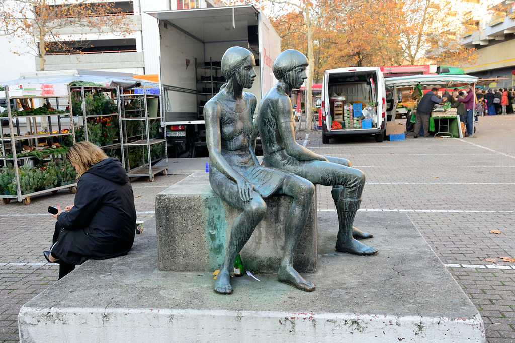 2085 Kunst im öffentlichen Raum; Bronzeskulptur zwei Frauen mit Kind,     auf dem  Wochenmarkt Bei den Höfen in Hamburg Jenfeld.