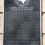Removal of Archives From Coldwater to Stratford (Stratford, Texas) Historic Marker on the Sherman County Courthouse in Stratford, Texas.  The marker reads:

“Removal of Archives From Coldwater to Stratford

On May 2, 1901, an election was held to determine whether the Sherman County seat should be moved from Coldwater (a ranching center in the central part of the county) to Stratford (a growing town on the new railroad). Partisan feelings ran high and the legality of certain votes was questioned. Because of a threatened injunction against the move, a special session of court was held at 1 a.m. on May 6. Votes were canvassed and, under cover of darkness, the county records were spirited to a tent about 2 blocks south of here. A horseman bringing the injunction to halt the move arrived too late. For several days apprehensive Stratford citizens kept an armed guard posted around the tent. Proponents of Coldwater then filed a suit titled &amp;quot;W.B. Slaughter Et Al. vs. D.W. Snyder Et Al.&amp;quot;, but by the time court convened, Stratford had been widely accepted as county seat and the suit was dismissed. Those who helped move the records included D.W. Snyder, County Judge; C.F. Rudolph, County Clerk; Dick Pincham, Sheriff; D.D. Spurlock, Deputy Sheriff; Tom Chambers, Treasurer; W.J. Potts and J.H. Bowman, Jr., Commissioners; and J.M. Upshaw, a hired freighter. (1969)”