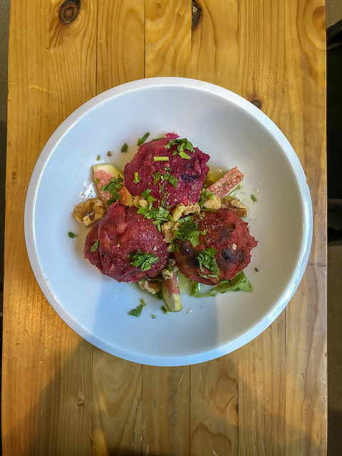 Dumplings made of beetroot with coriander, figs and walnuts on wooden table