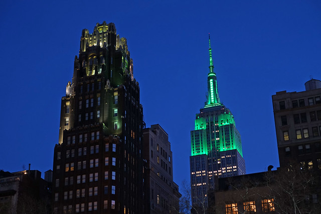 Bryant Park Hotel and the Empire State Building NHL & NHP lighting in green in honor of Earth Day as seen from Bryant Park in Midtown Manhattan in New York City, NY