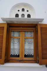Lace curtains and carved marble above window, Pyrgos village, Tinos