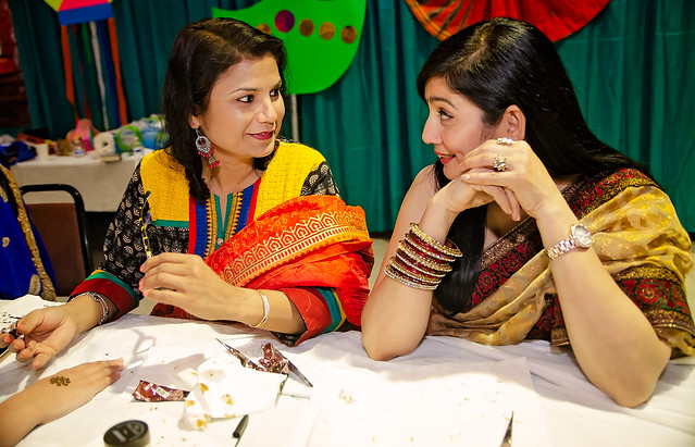 Indian women talk while applying mehndi at the 34th annual Mobile International Festival in Mobile Alabama
