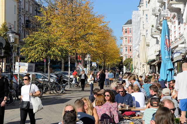 9233    Sonniger Herbstsonntag auf der Piazza im Hamburger Stadtteil Sternschanze; im Szeneviertel Hamburgs haben am Schulterblatt Restaurants und Cafés ihren Gäste Tische in die Sonne gestellt.