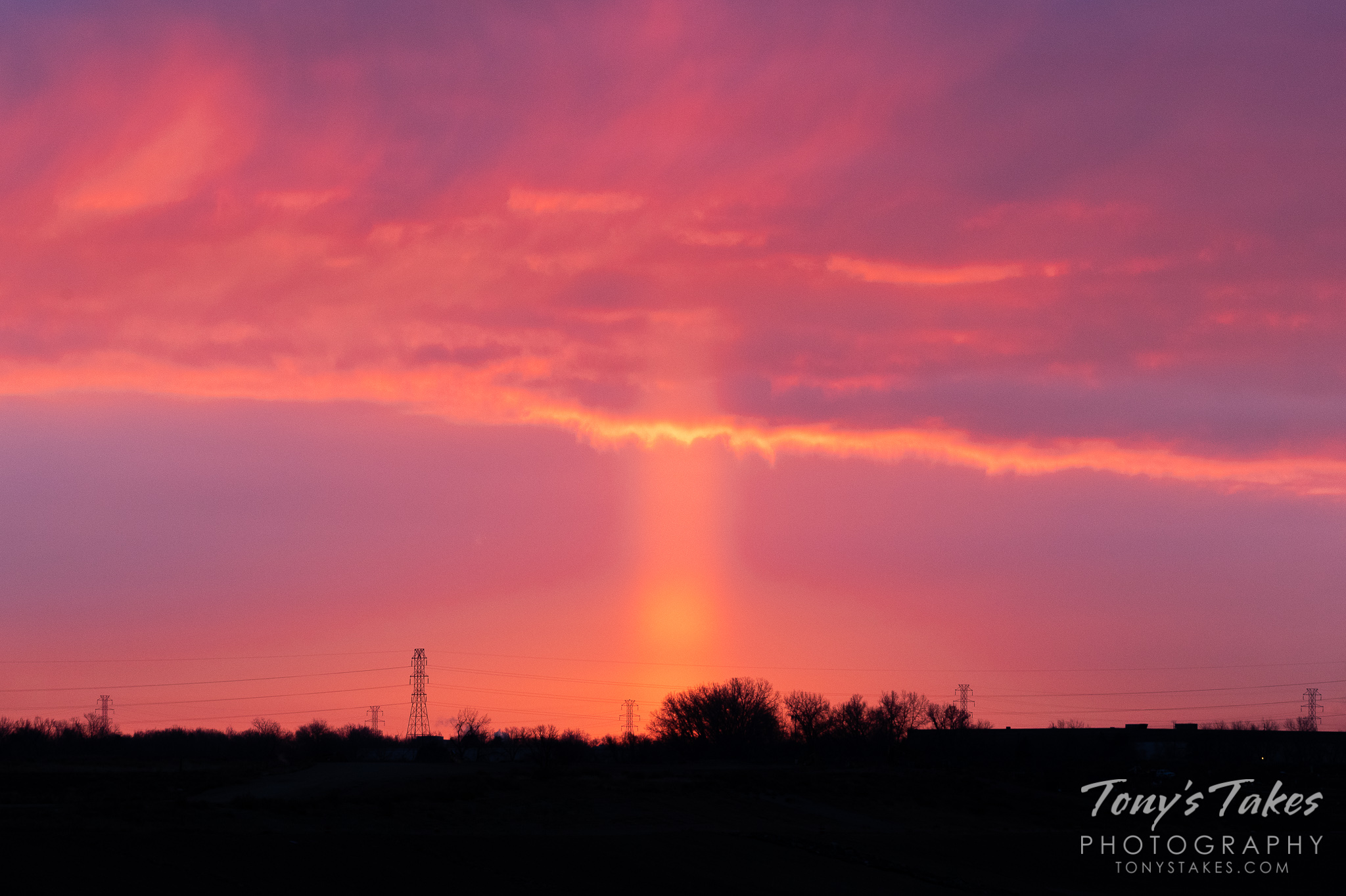 A sun pillar rises from the ground to the sky on the Colorado plains. (© Tony’s Takes)