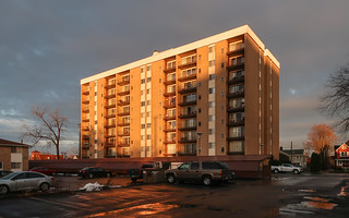 Apartments of recessed balconies from 1966, on a sunny December evening in Michigan, during snowmelt.