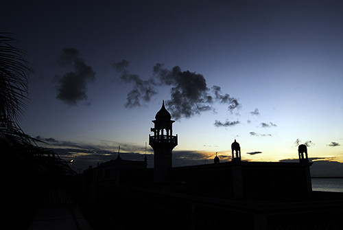 Mozambique, Ilha de Mozambique, silhouette of mosque by sea against sky at dusk