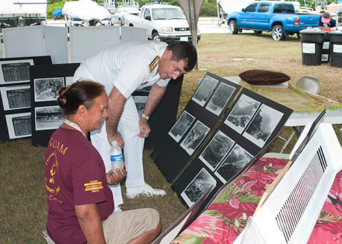SANT RITA, Guam (April 14, 2012) Rear Adm. Paul Bushong, Commander Joint Region Marianas, and Toni Ramirez, a island historian, look over Pre-World War II photos of Sumay Village which was once located where Naval Base Guam now sits. Photo  courtesy of US Navy Base Guam's Joint Region Marianas Public Affairs Office. U.S. Navy photo by Mass Communication Specialist 3rd Class Corey Hensley