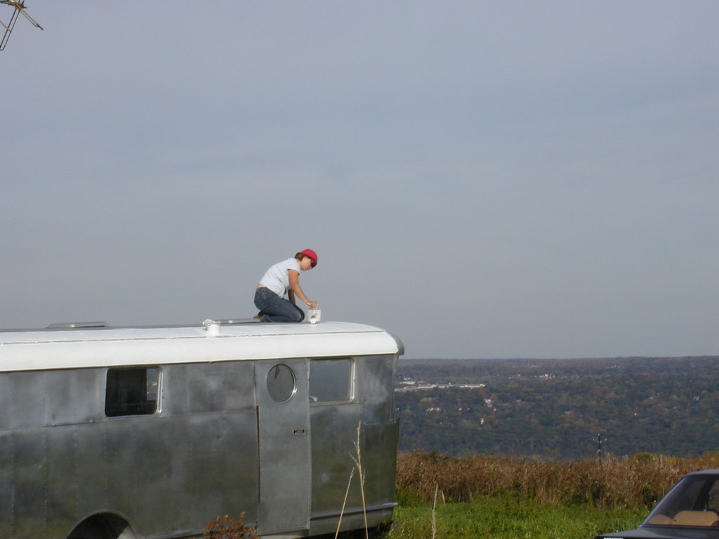 Worker applying a white roof coating