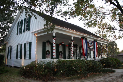 windows sunset usa architecture texas patriotic flags historic christmaslights christmasdecorations porch redwhiteblue smalltowns griffinhouse harriscounty christmasgarland tomballtx texasscenes built1860 tomballmuseumcenter christmascandlelighttour movedtocomplex builtbyeugenepilot