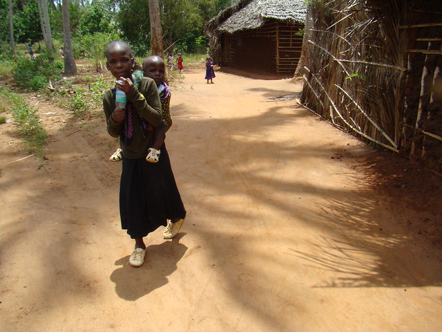 joven con niño en su espalda su gente pequeña aldea Zanzíbar Tanzania 13