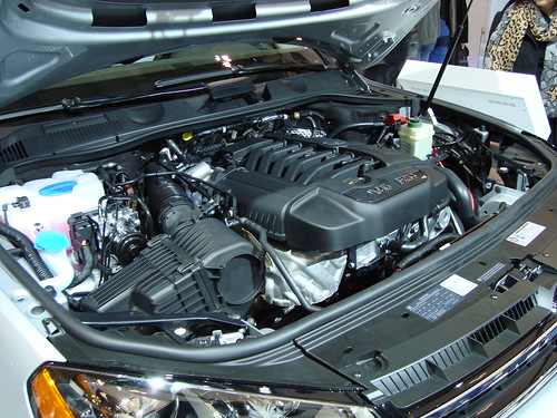 An engine under the hood of a silver sedan