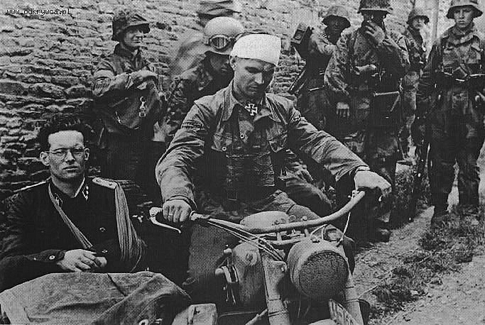 SS-Hauptsturmführer Rudolf von Ribbentrop, 3. Kompanie, I./SS-PzRgt 12 in the sidecar and driving the motorcycle is SS-Obersturmbannführer Max Wünsche, Rgt. Komm. of SS-PzRgt 12, after visited the survivors of III Zug 15/25 in Rots, Normandy. 9 June 1944.