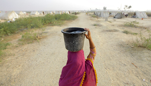 Reshma carrying water by Oxfam NZ, Reshma, 10 years old, from Qambar Shahdadkot, who currently lives in Shahbaz camp with her extended 