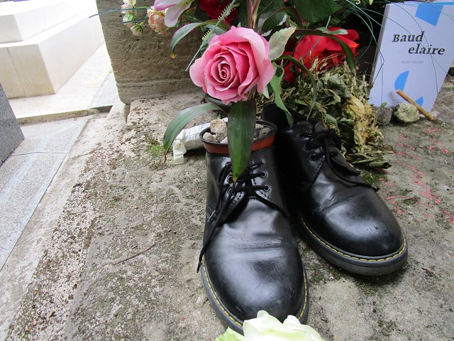 On French poet, Baudelaire's grave, a pair of black shoes, one of which was full of pebbles