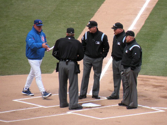 Manager Mike Quade Approaches Umpires with Cubs Lineup in Hand