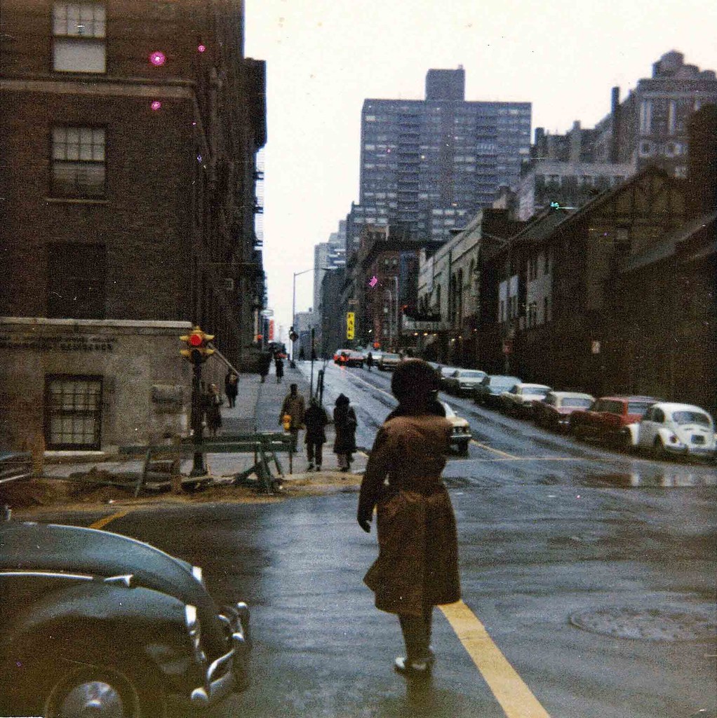 Manhattan Street on a rainy day with several VW Bugs and a dude with a seri...