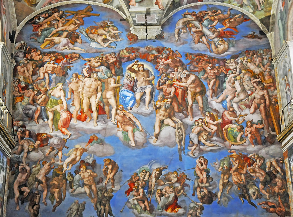 A photo of the Last Judgement mural on the wall of the Vatican City Sistine Chapel. Blues, reds and greens are vivid and various people, are shown in a heaven-like setting. 
