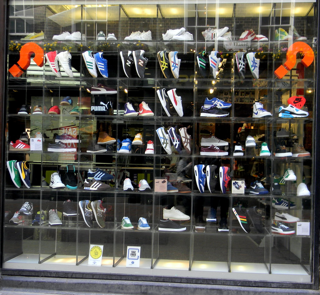В магазине на витрину выставили наборы. Витрина для обуви. Витрина кроссовок. Витрина обувного магазина. Витрина магазина обуви.