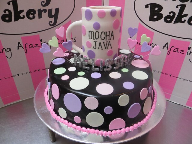 Wicked chocolate cake iced in black ganache, pastel colored polka dots, 3D glittered name and fondant coffee mug with wired hearts