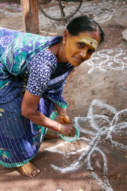 Drawing kolam in front of her house,Kanchipuram,Tamil Nadu, India.