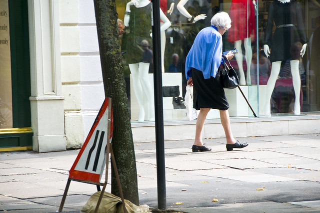 Old Lady Walking Past a Shop Window