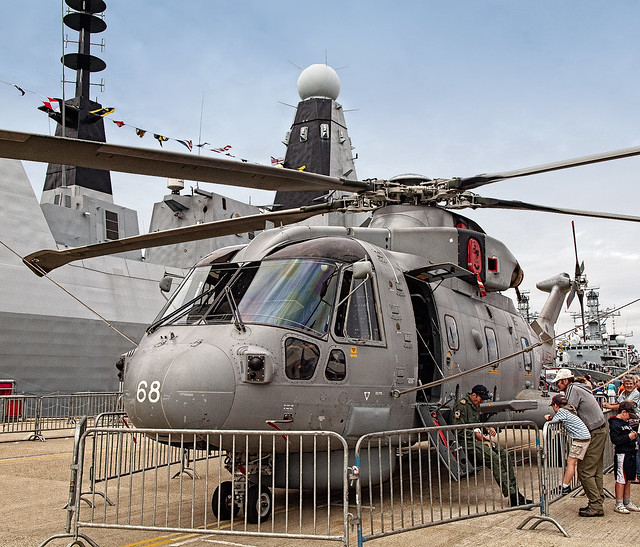 A Royal Navy Merlin helicopter in front of the new Type 45 destroyer HMS Dauntless at Portsmouth Navy Day 2010