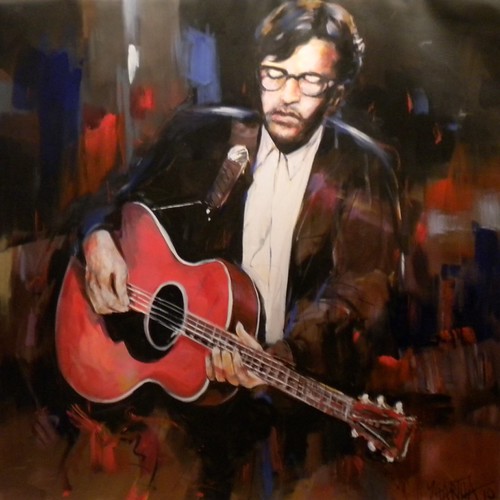 Seated musician holding a red acoustic guitar