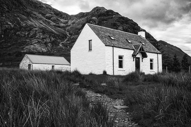 Little white house against a mountain in Scottish Highlands, Scotland