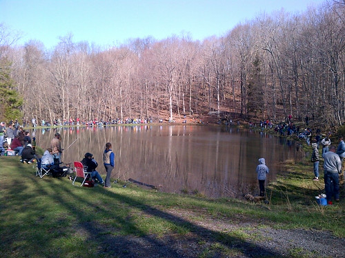 Photo of group of kids and adults around a small lake
