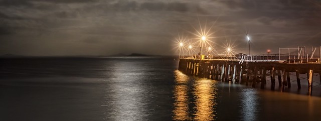 Esperance tanker jetty with a full moon just risen. HDR with three exposures to get the detail underneath and the highlights of the reflected moon and the jetty lights. Stars from the lens, no filters.
