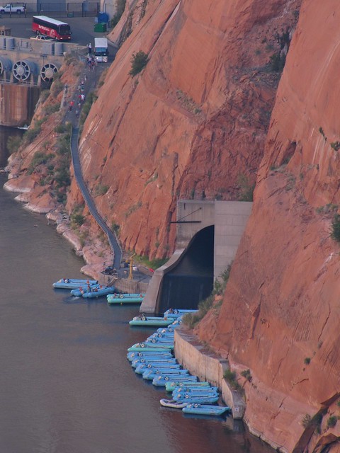 Rafts waiting for customers below the outlet of the river diversion tunnel used to channel the river while they were building the dam back in the '50s.  Note the people walking down from the buses parked above.