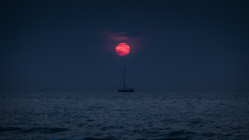 Under The Red Sun by Gilderic Photography, The sun is dying again.
Changing his yellow to a dark red
Diving into the sea
And being born again t