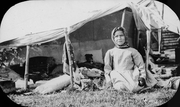 First Nations girl in front of a tent / Fille des Premières Nations devant une tente