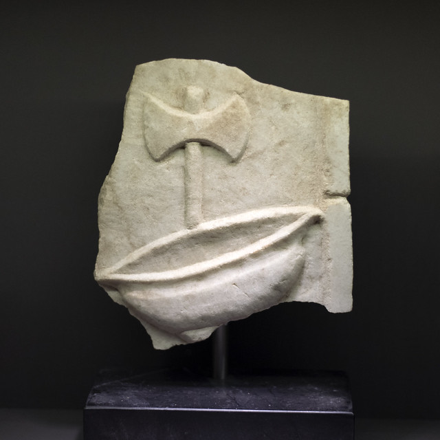 Marble plaque with relief representing double axe and upturned pilos from Samothrace