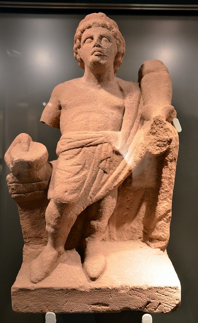 Statue in yellow-red sandstone of a genius holding a double cornucopia, found in the pit of the Mithraeum, Museum Schloss Fechenbach, Dieburg, Germany