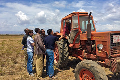 IFPRI researcher Xiaobo Zhang shaking hands with a tractor driver in Ethiopia