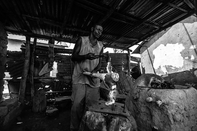 African blacksmith works with iron