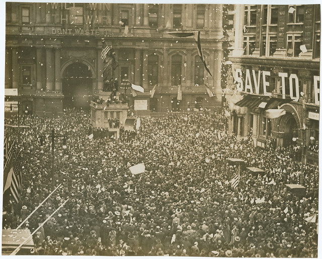 First News of Peace! Confetti thrown by happy crowds. Liberty sings. Flags waved. Nov. 11-1918.