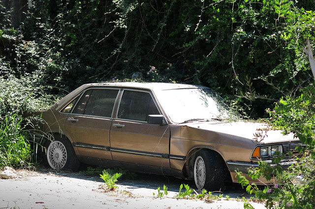 An abandoned Audi in the grounds of the derelict apartment block