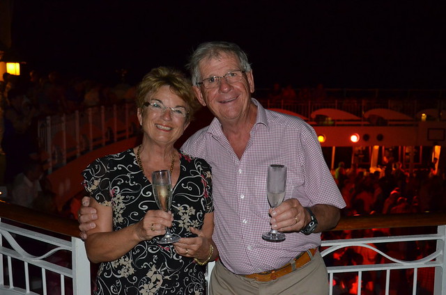 Elderly couple posing on a cruiseship  with champagne