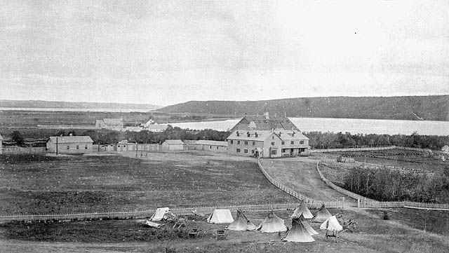 Fort Qu’Appelle Indian Industrial School showing tents, [Red River carts] and teepees... / L’école industrielle indienne de Fort Qu’Appelle, avec des tentes, [des charrettes de la rivière Rouge] et des tipis...