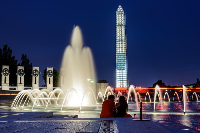 World War II Memorial fountains with lit Washington Monument in background