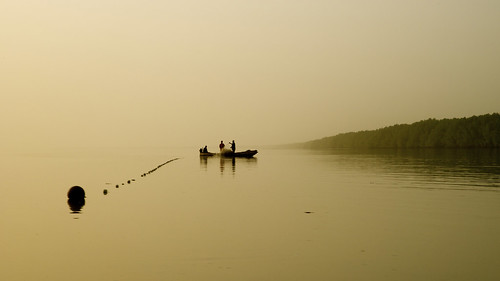 mariusz kluzniak africa western senegal gambia gambian river fishing boat fishnet fisherman sunset orange