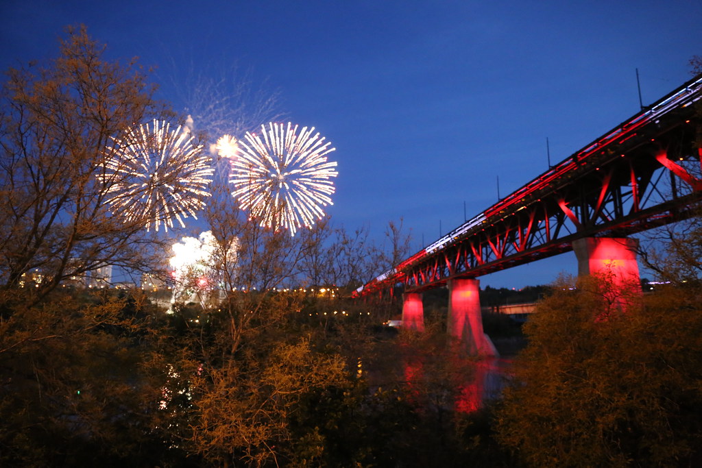 Fireworks over the High Level Bridge, lit up with red and white for Canada Day