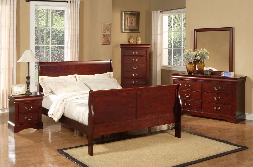 Louis Philippe style sleigh bed in a dark wood. Moreover, there are two dressers and a bedside table that also match the sleigh bed. 