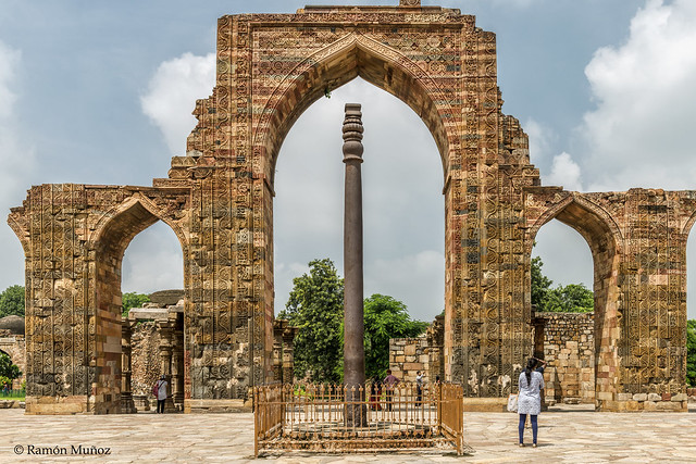 DSC5626 Mezquita Quwwat-ul-Islam, patio con la puerta de entrada a la mezquita y el Pilar de Hierro delante, finales del siglo XII, Delhi