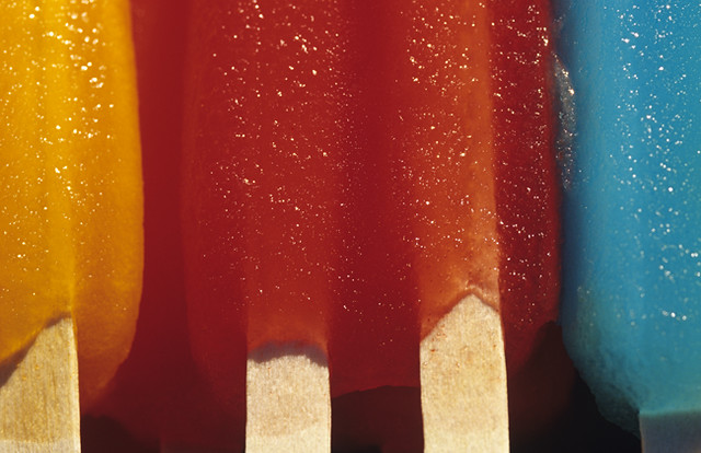 Rows of colorful melting popsicles laying out in the summer heat